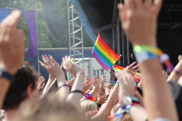 People's hand up at a concert holding pride flags